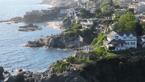 Drone view of American flag waving by wind the Pacific Ocean, Laguna beach, Orange County, California, USA. Scenic shot of private villas located on rocks with beach. Wonderful landmark, 4k footage - Powered by Shutterstock - Get 15% off with code: PIKWIZARD15