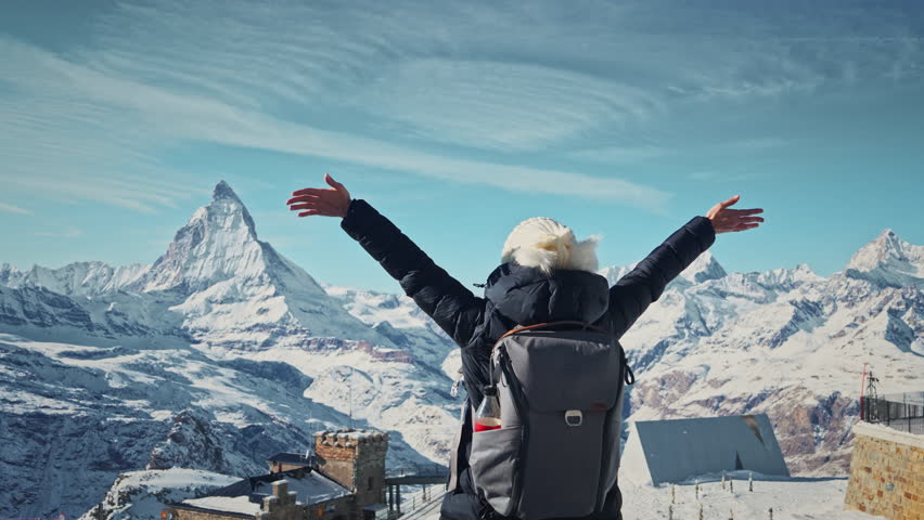 Happy young woman raising arms euphorically in breathtaking Swiss Alps mountain, Switzerland Matterhorn, Tourist journey trip concept | Shutterstock HD Video #1111966649