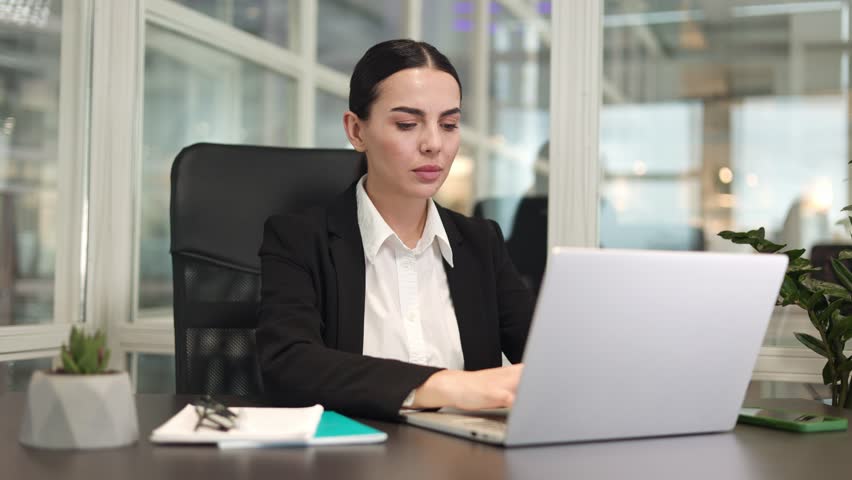 Unwell business woman sitting in modern office and using wireless laptop while experiencing severe stomachache. Caucasian qualified brunette working and suffering from pain in bright building. | Shutterstock HD Video #1111967745