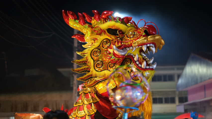 person performing a dragon dance during Chinese New Year celebrations is believed to bring blessings and good fortune for the upcoming year. Hidden under a dragon costume, performers move in harmony Royalty-Free Stock Footage #1111971655