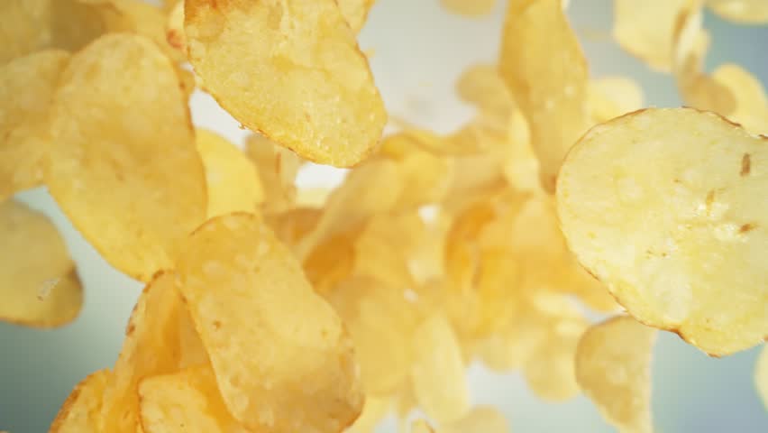 Super Slow Motion Shot of Premium Potato Chips Flying Towards Camera on Light Background at 1000fps. | Shutterstock HD Video #1111972349