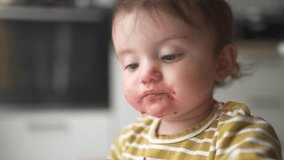 grimy baby eats with her hands from a plate. development of fine motor skills family kid dream concept. funny video baby dirty eats food from a lifestyle plate with his hands. dirty baby eats