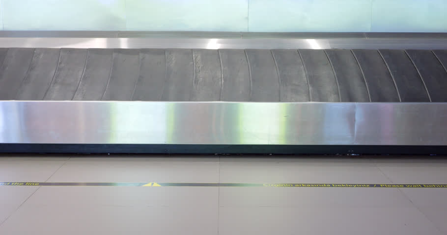 Empty slat conveyor for luggage at baggage reclaim hall of modern airport, slow motion shot. Black plates move in steel frame, no suitcases delivered to this carousel yet | Shutterstock HD Video #1111974835