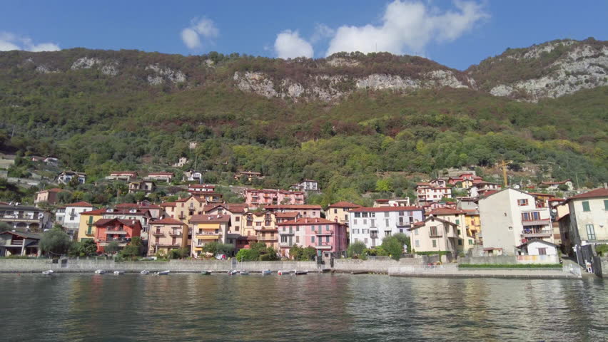 View of Tremezzo town in lake Como, Lombardy, Italy, from ferryboat while cruising pass. Many beautiful architecture which are restaurants and hotel accommodations on waterfront are very impressive. M | Shutterstock HD Video #1111985559