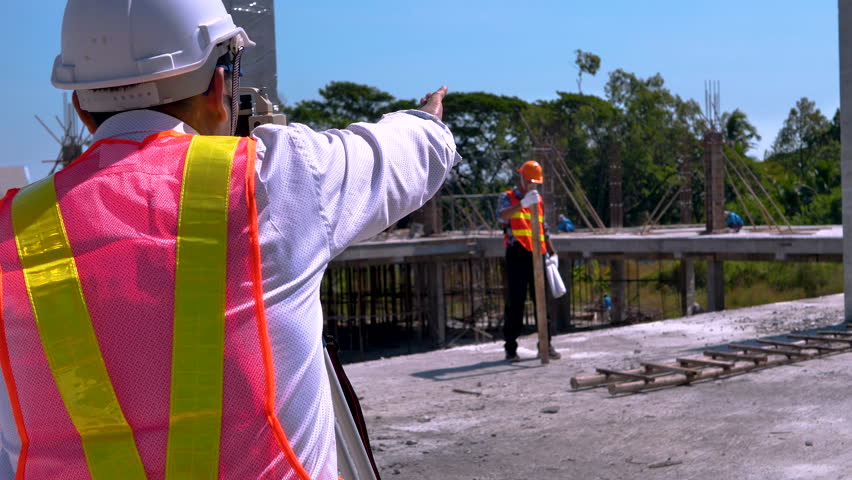 Engineer or surveyor worker working with theodolite transit equipment at outdoors construction site. 4K Royalty-Free Stock Footage #1111985817