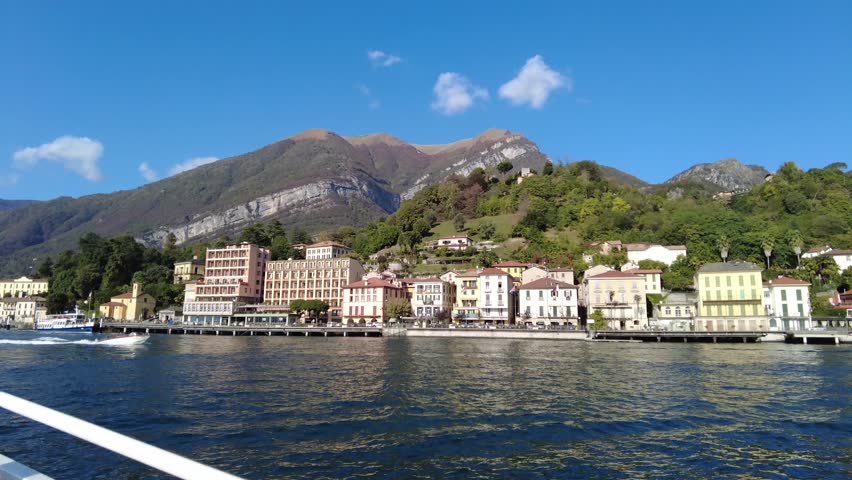 Closer view of Tremezzo town in lake Como, Lombardy, Italy, from ferryboat while getting to Tremezzo pier. Many beautiful architecture which are restaurants and hotel accommodations on waterfront are  | Shutterstock HD Video #1111985857