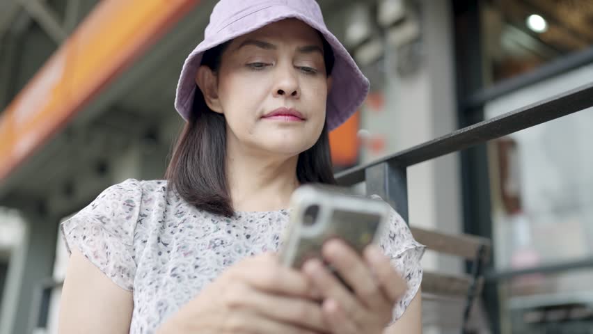 Stylish middle-aged woman drinking coffee holding a mobile phone Attractive woman orders online, technology concept | Shutterstock HD Video #1111985873