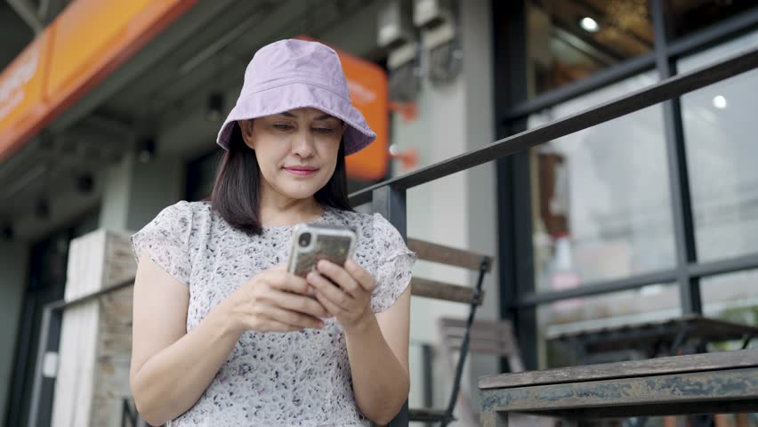Modern lifestyle woman texting on smartphone app sitting in modern coffee shop in city
 | Shutterstock HD Video #1111985895
