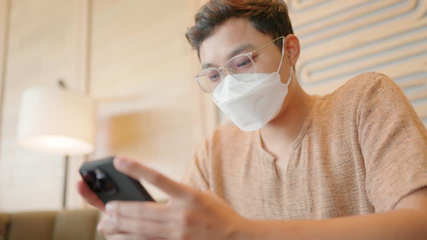 Male user sitting at shopping center in medical mask quarantine rules Businessmen chatting online, watching videos | Shutterstock HD Video #1111986469