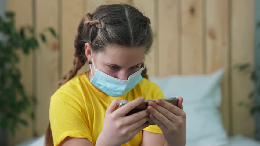Happy family concept. child in quarantine at home. baby on sofa in mask with a phone. online video call. video call in quarantine with family. Internet call. communication during quarantine by phone | Shutterstock HD Video #1111987769