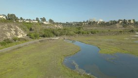 An aerial footage over the city of Newport Beach surrounded by buildings and a still pond