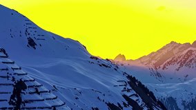 Golden sky over snowy mountain landscape in a winter time-lapse