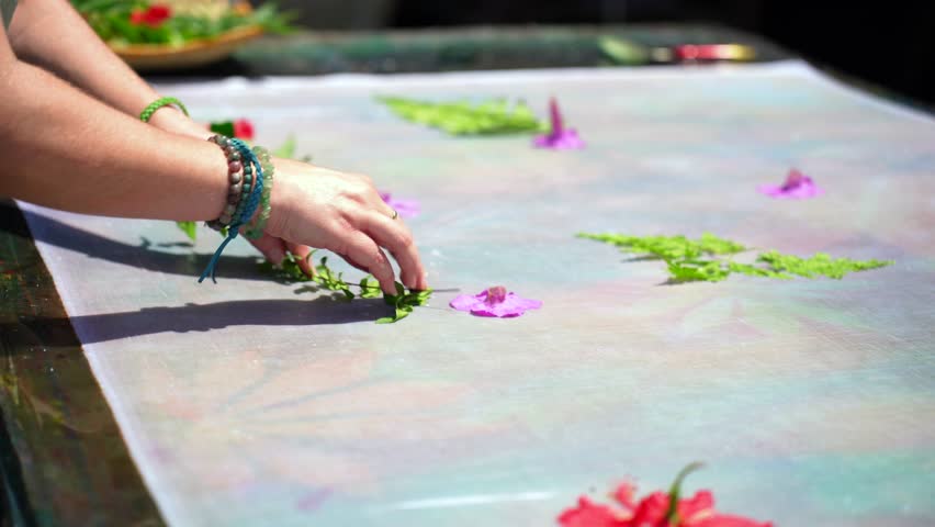Clients learning homemade batik, sarong, pareo, placing green leaves and flowers on white cloth, Mahe Seychelles 25fps 1 | Shutterstock HD Video #1111988887