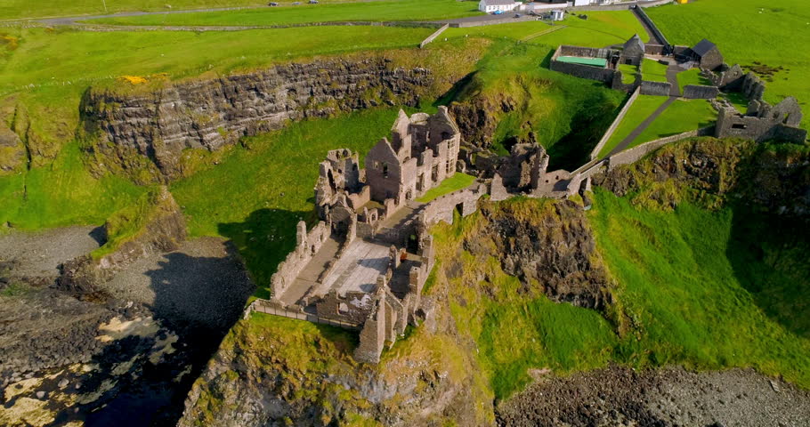 Aerial orbital shot moving anti-clockwise above Dunluce Castle in Northern Ireland Royalty-Free Stock Footage #1111988895