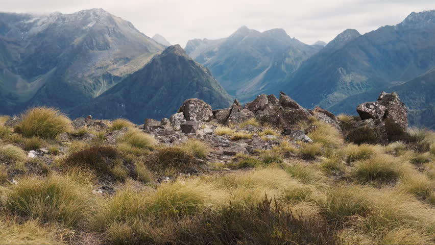 Epic New Zealand rugged mountain landscape with pointy rocks in the foreground.