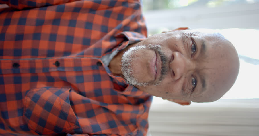 Vertical video of portrait of happy senior biracial man having video call at home, slow motion. Domestic life, retirement, technology and lifestyle, unaltered. | Shutterstock HD Video #1111990425