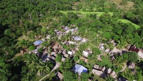 African village during sunny day in the jungle. Roofs of wooden houses in Africa. Panoramic aerial drone clip.