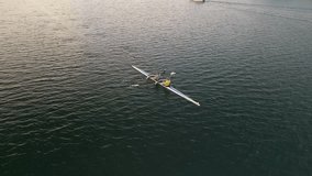 Team rowing on calm ocean water early in the morning Aerial view. A women's rowing team rows in an ocean bay at sunrise. Sport canoe driven by a team of two women practicing early in the morning. - Powered by Shutterstock - Get 15% off with code: PIKWIZARD15