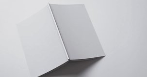 Video of book with white blank cover pages and copy space on white background. Book, literature, paper, writing, texture and materials concept.