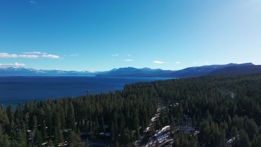 Drone shot following a road next to Lake Tahoe in California | Shutterstock HD Video #1111999965
