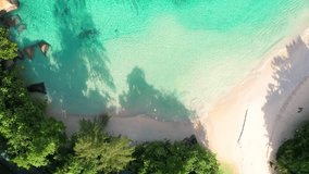 bird eye drone footage of white sandy beach, calm turquoise ocean with granite stones, Mahe, Seychelles 60fps