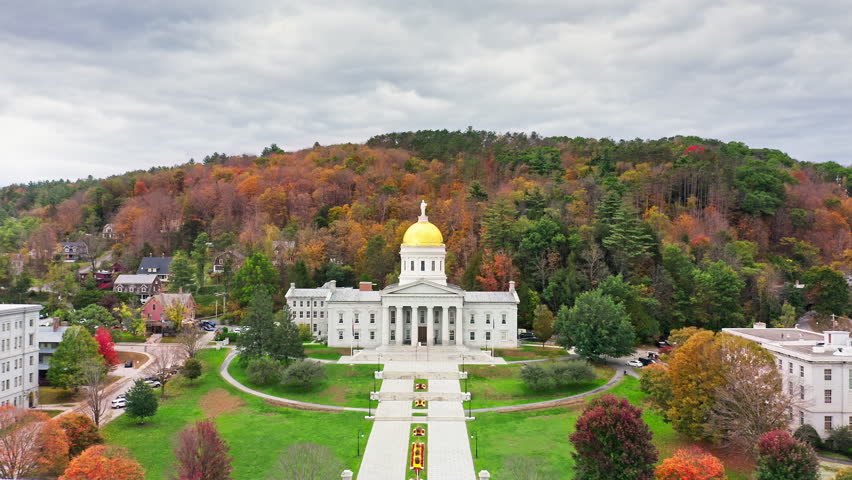 Aerial establishing shot of Vermont State House, in Montpelier, VT with slow camera approach towards the iconic golden dome. The capitol is the seat of the Vermont General Assembly.