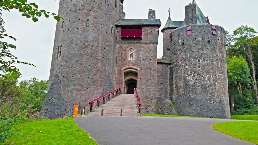 Red Castell Coch with great towers and conical roofs in Cardiff, Wales. Castle built in the gothic-revival style surrounded by ancient beech woods of Fforest Fawr like a vision from a fairy tale.