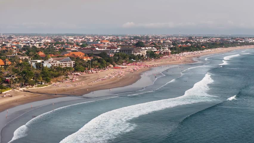 Aerial 4K footage of Seminyak beach coastline. The famous and luxury Kuta beach resort in southern Bali, Indonesia. Sunny drone video Royalty-Free Stock Footage #1112004657