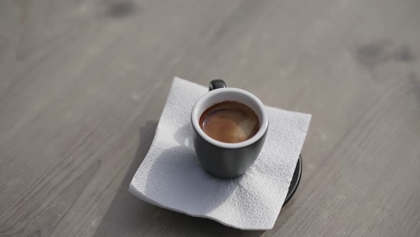 Hand pouring sugar in black cup of coffee on cafe bar table, selective focus cinematic slow motion shot | Shutterstock HD Video #1112006703