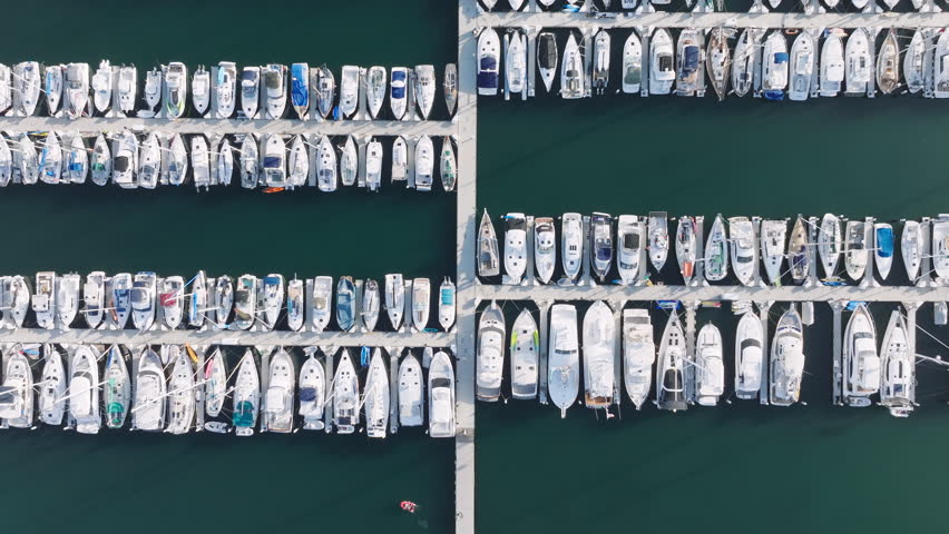 Birds eye view of Santa Barbara city Harbor at Pacific coast, California, USA. Top shot of luxury boats and motorboats docked in the marina. Aerial view on the port from Point Castillo, 4k footage Royalty-Free Stock Footage #1112007889