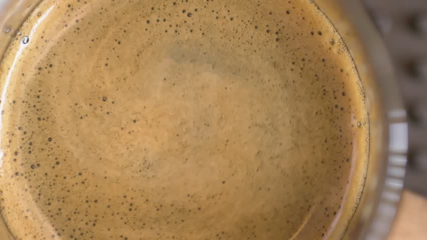 Drops of coffee extract into the measuring cup produce beautiful crema foam. | Shutterstock HD Video #1112013325