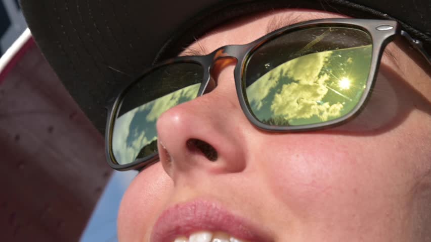 Close-up face of caucasian young woman in sunglasses smiling. Portrait of a stylish traveler girl in slow motion. Reflection of mountains and sky in sunglasses Royalty-Free Stock Footage #1112016617