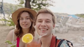 Happy caucasian couple have fun together and drinking cocktails at poolside. Young funny boyfriend with girlfriend recording video how the drink mojito on vacation. Self portrait of two lovers at - Powered by Shutterstock - Get 15% off with code: PIKWIZARD15