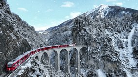 Snow falling and Train passing through famous mountain in Filisur, Switzerland. Train express in Swiss Alps snow winter scenery.  - Powered by Shutterstock - Get 15% off with code: PIKWIZARD15
