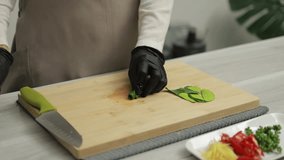 Cook preparing to cook Thai food by cutting Kaffir lime leaves stock video, Homemade cooking concept