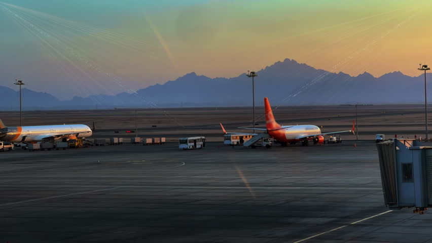 Time Lapse vehicles and workers refilling, loading cargo in to airplane at the airport with holographic planet Earth. Logistic transportation