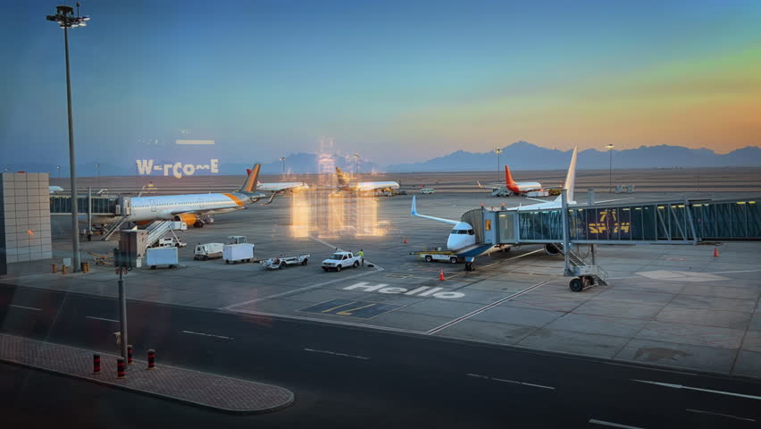 Time Lapse vehicles and workers refilling, loading cargo in to airplane at the airport with holographic city. Logistic transportation