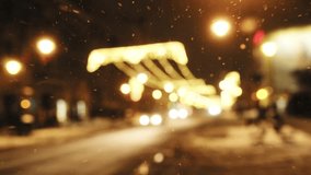 Defocused winter city lights bokeh and falling snow as a Christmas holiday background, 4K video footage