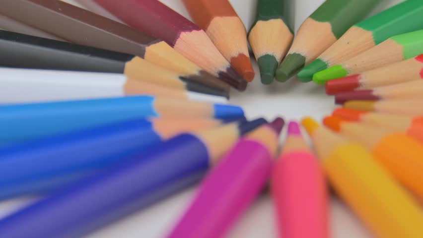 Colorful pencils rotate as sun rays background. Rainbow pencils for drawing. Assortment of colored pencils. Back to school concept