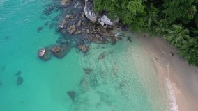 Drone footage of white sandy beach, coconut palm trees, turquoise water, granite stones on sunset beach, Mahe Seychelles 30fps 1