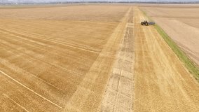aerial video footage in 4K resolution of a tractor on a big acre in germany. Grubbering a field with a big agricultural machine