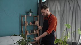 Handsome man taking picture on phone of dried and sunburn leaf of potted plant. Houseplants diseases concept. Home gardening mobile app. - Powered by Shutterstock - Get 15% off with code: PIKWIZARD15