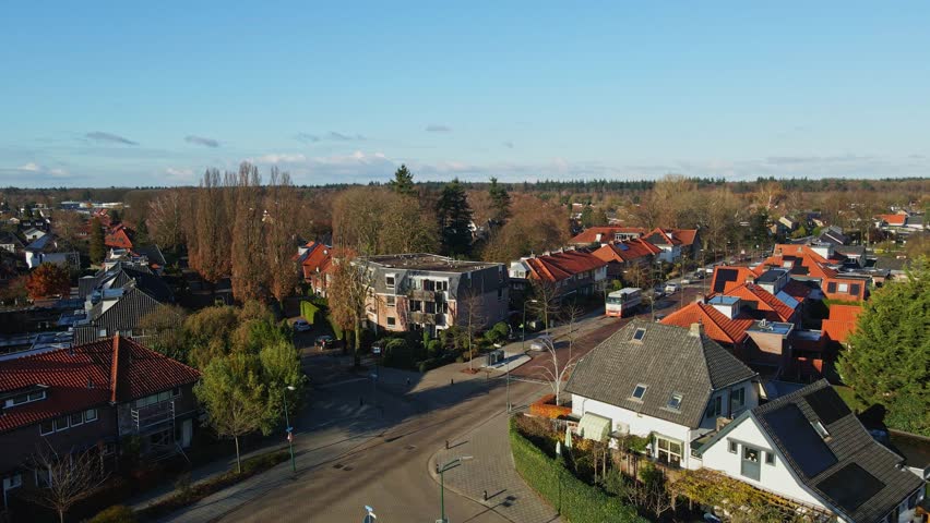 Low aerial of beautiful suburban neighborhood with two driving cars and a cyclist on the calm road | Shutterstock HD Video #1112039403