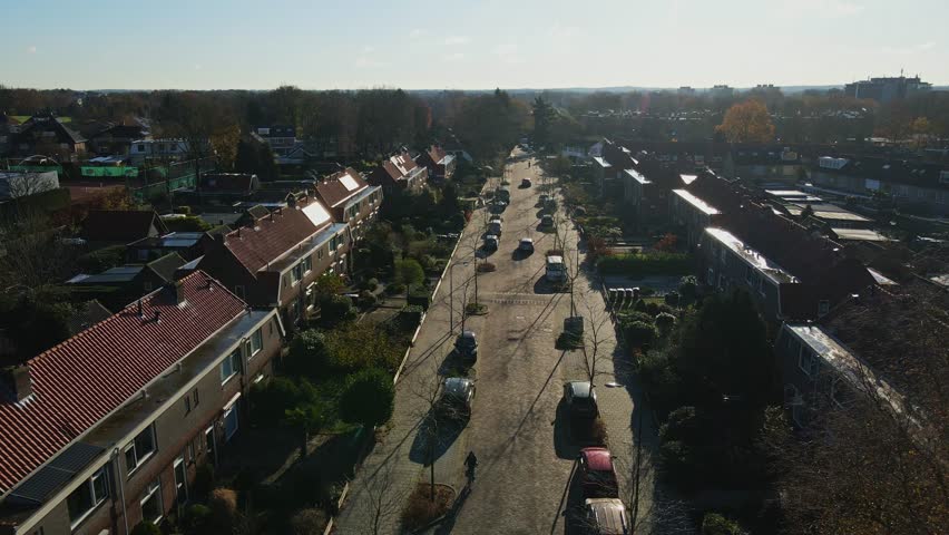 Low aerial of a cyclist cycling on a calm road in a peaceful suburban neighborhood on a sunny day | Shutterstock HD Video #1112039405