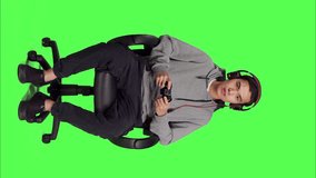 Front view of guy having fun with competition over full body greenscreen background, playing online videogames with joystick. Young person enjoying online gaming tournament, game player with skill.