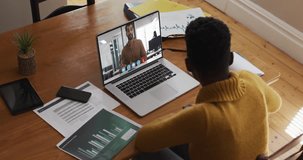 Animation of heart eyes face emojis over african american woman having video call on laptop. Social media networking and business technology concept