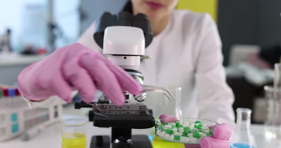 Scientist technologist examines medical pills under microscope. Pharmacy and healthcare concept Royalty-Free Stock Footage #1112051545