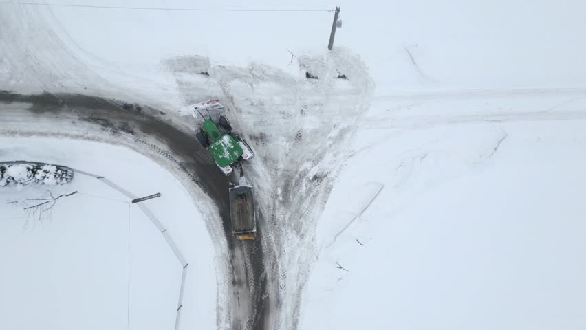 Vertical video. Top view of snow removal tractor on the road in winter. | Shutterstock HD Video #1112051769