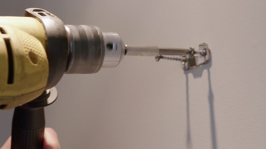 man drilla wall for hang a paint