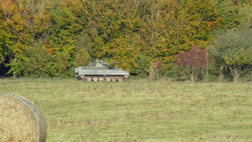 a British army Warrior FV510 IFV tank moving along woodland cover on a military exercise. Wilts UK